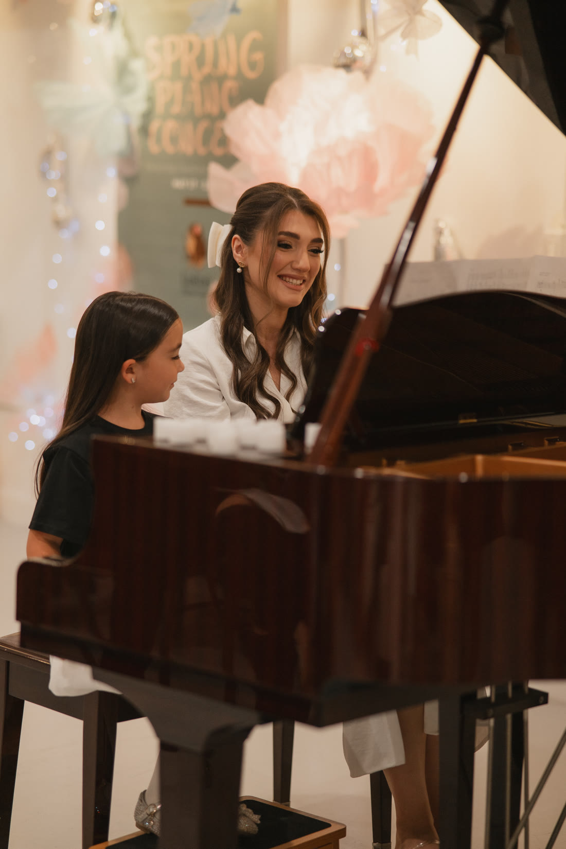 Luiza teaching a student at the piano